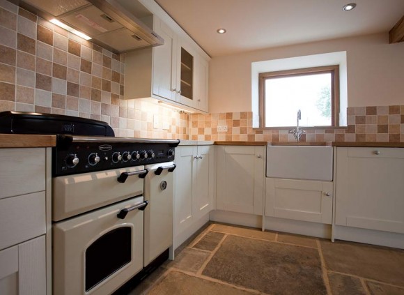 Kitchen with York stone flagged floor and integrated appliances.